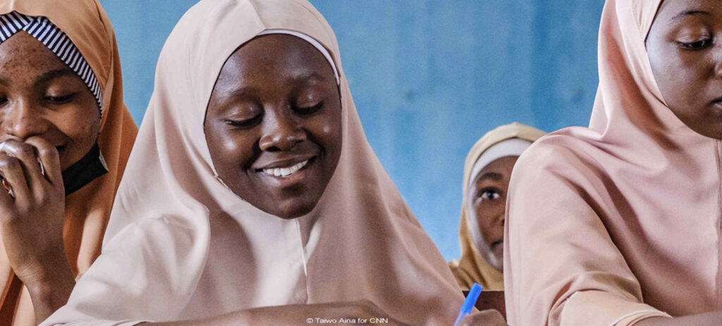 Group of women wearing hijabs smiling and laughing together in close-up portrait