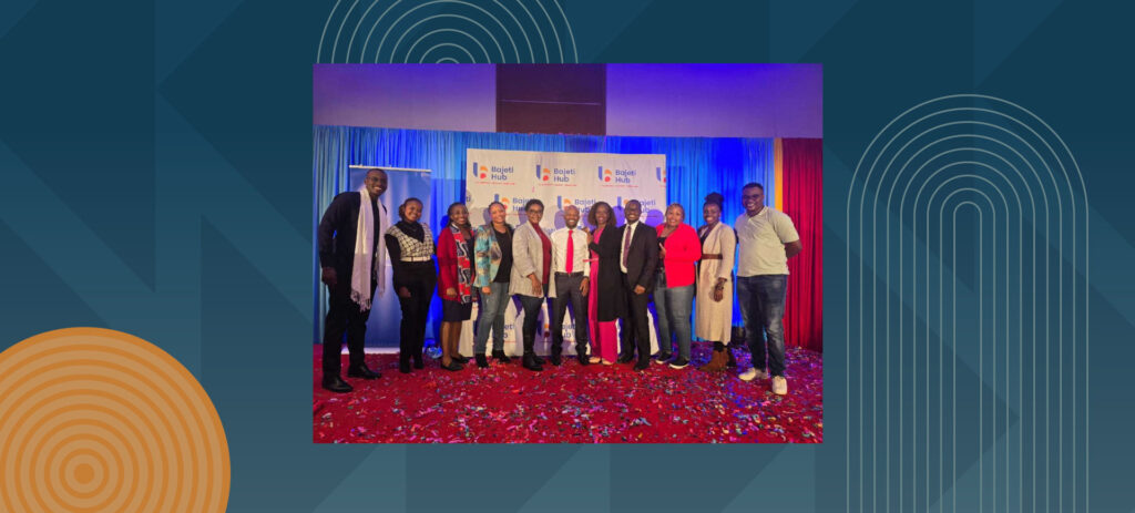 Group of professionals posing on stage with Bajeti Hub branding and colorful lighting backdrop