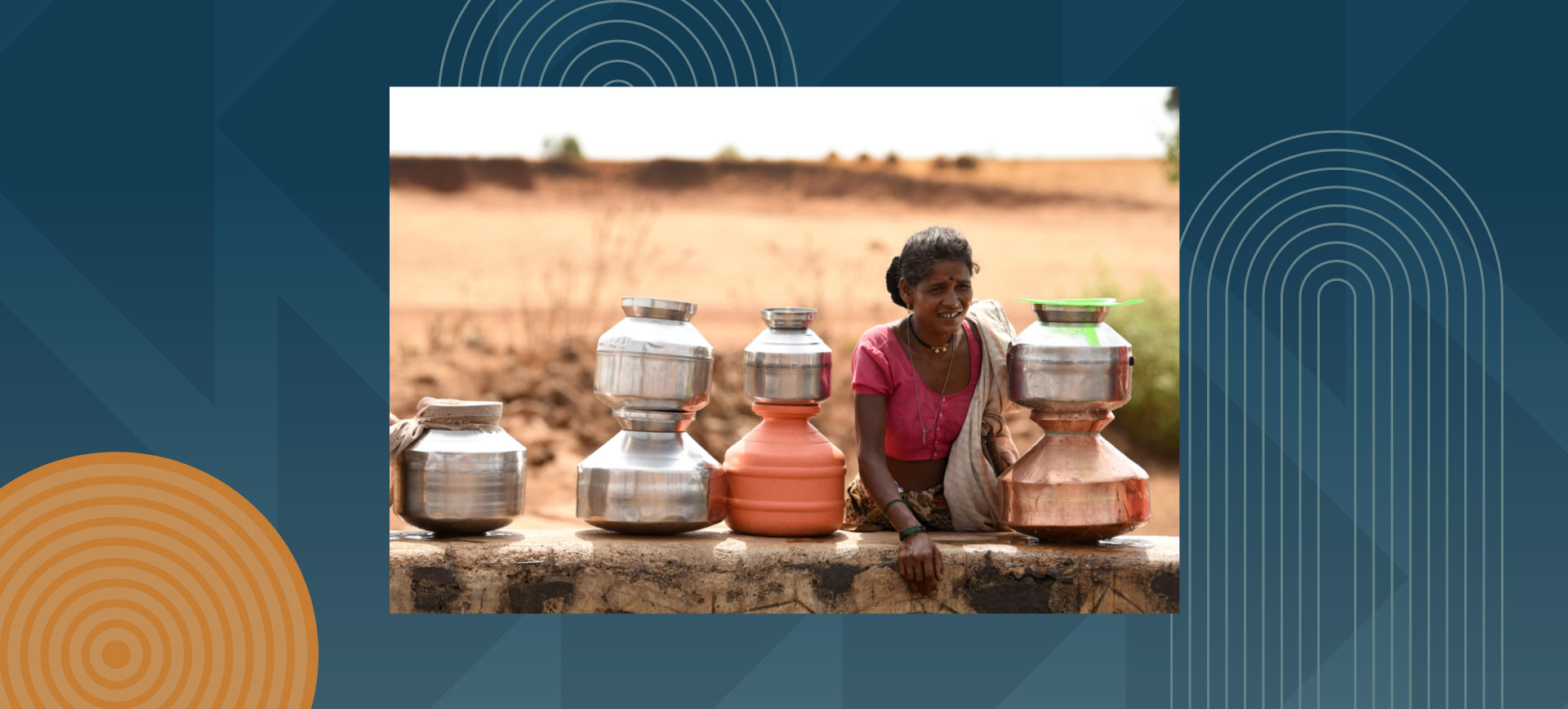 Woman sitting with metal water containers in rural setting during golden hour